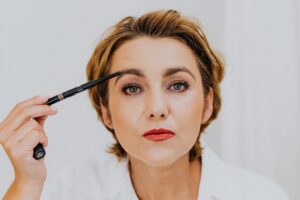眉毛ペンシルでメイクする女性