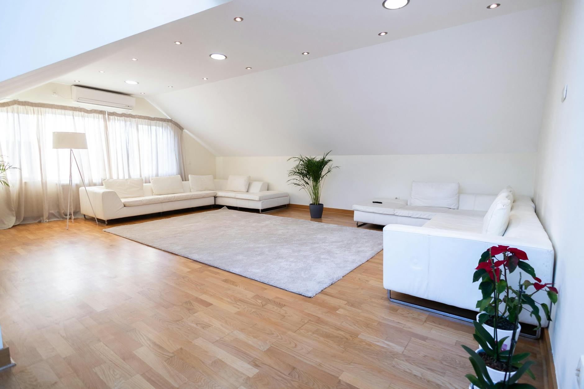 Bright modern living room with white sofas and wooden floor, ideal for relaxatio