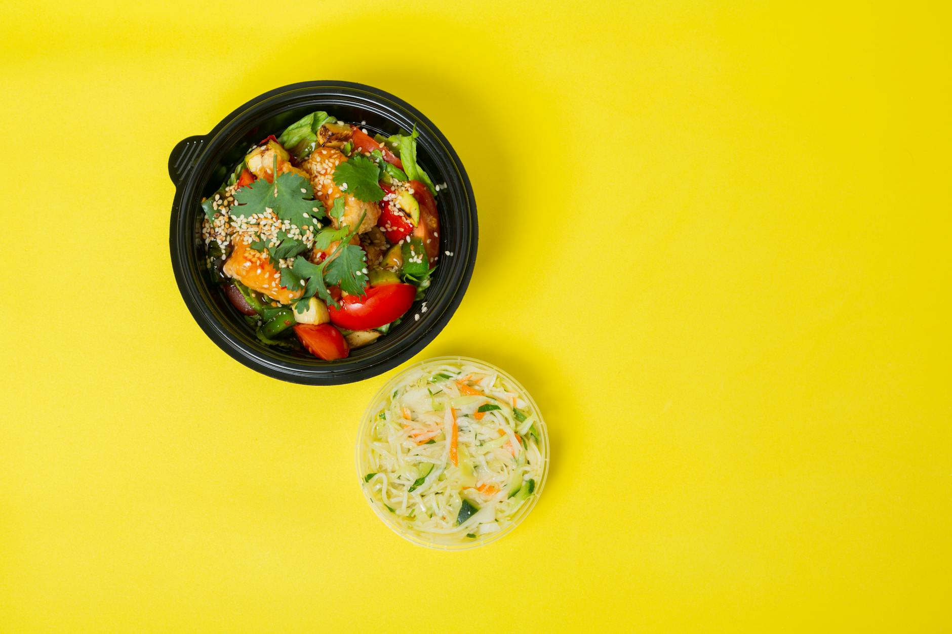 Colorful vegetable salad in a bowl with a yellow background for healthy eating c