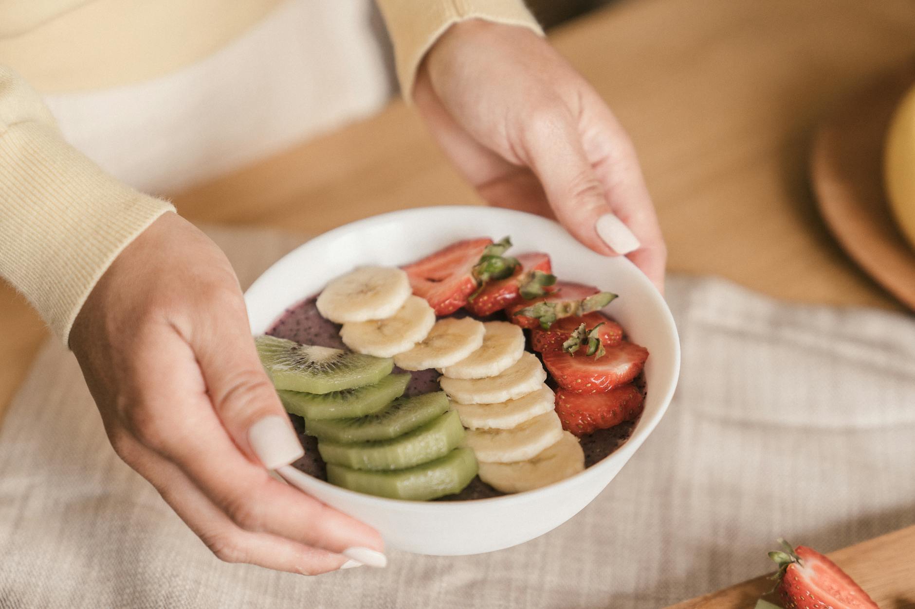 Delicious smoothie bowl topped with fresh fruits like kiwi, banana, and strawber