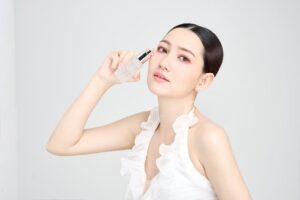 Serene model holding skincare product in modern beauty photoshoot.