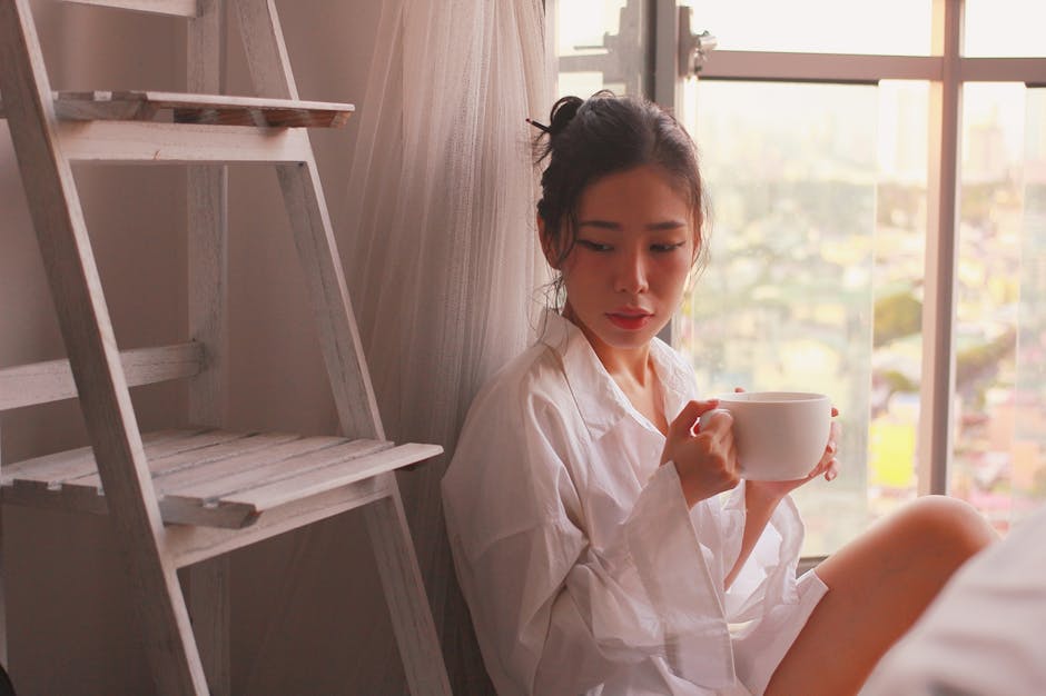 Asian woman enjoying a calm morning indoors in Makati, Philippines.