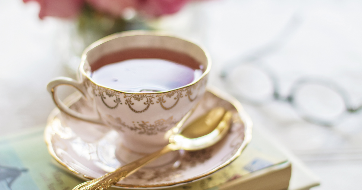 紅茶のカップと眼鏡と本が並ぶテーブル
