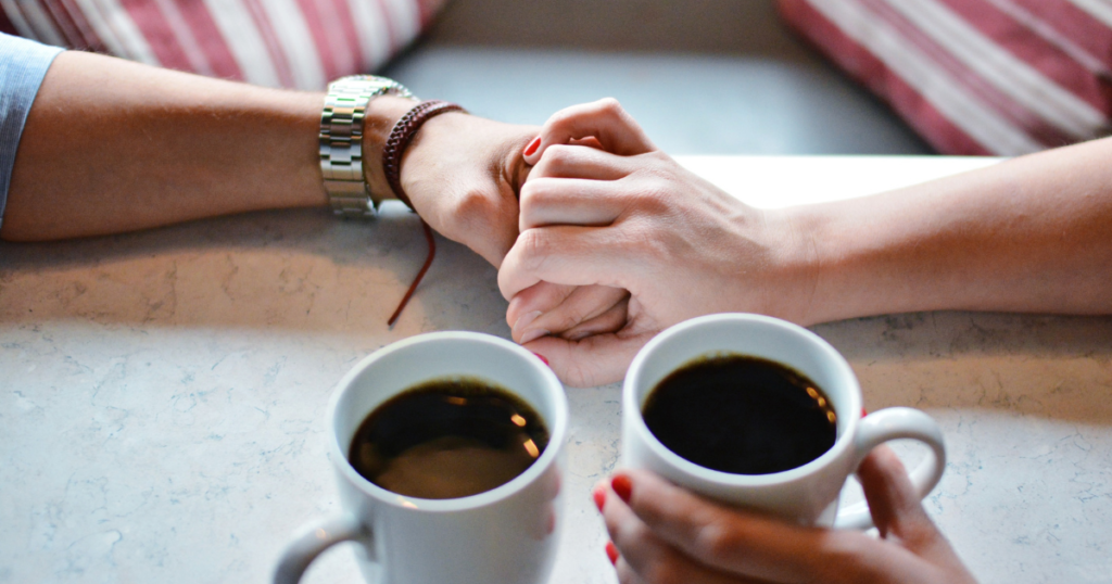 コーヒーで手を重ねる夫婦