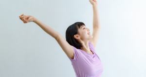 [exercise] 両手を上げ伸びをするタンクトップ女性（人物あり）