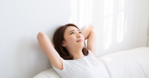 白ソファで頭の後ろに手を組みリラックス