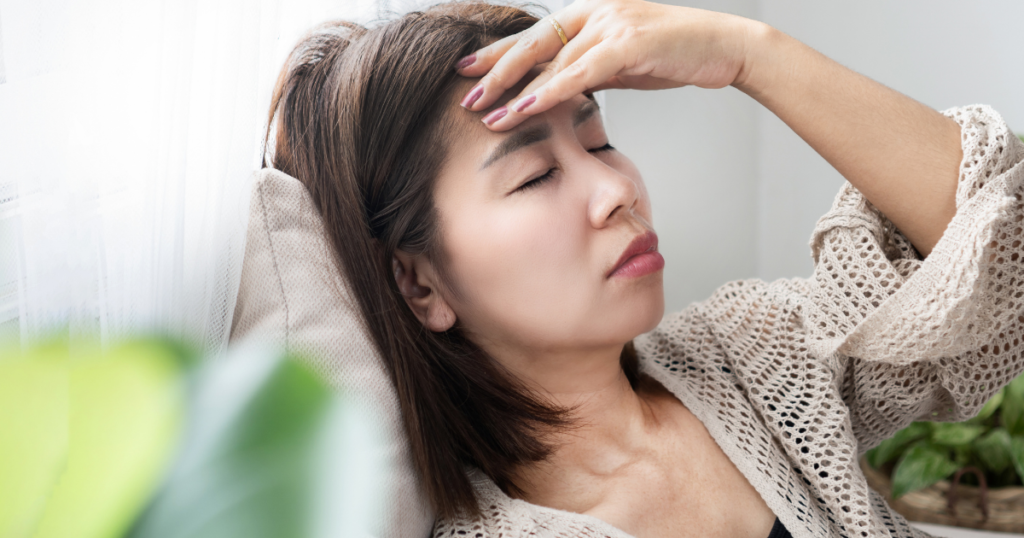 だるさを感じて目を閉じる女性