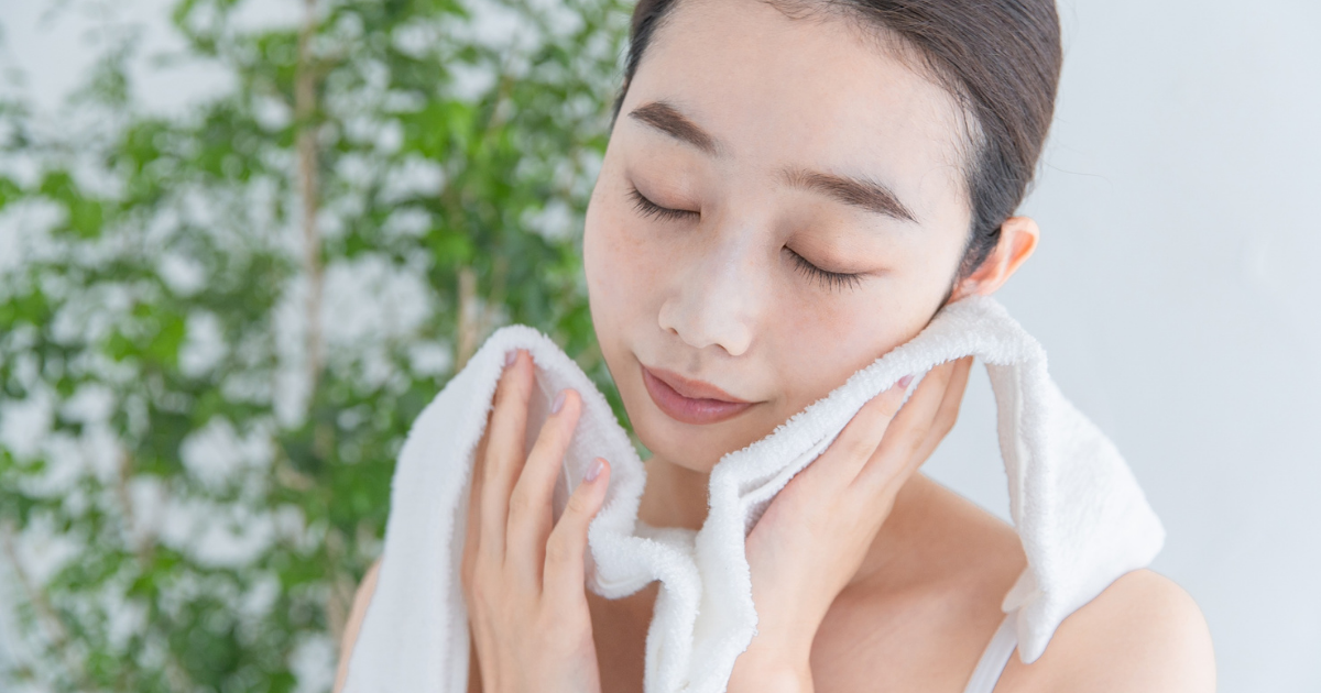 タオルで顔をやさしく拭く女性