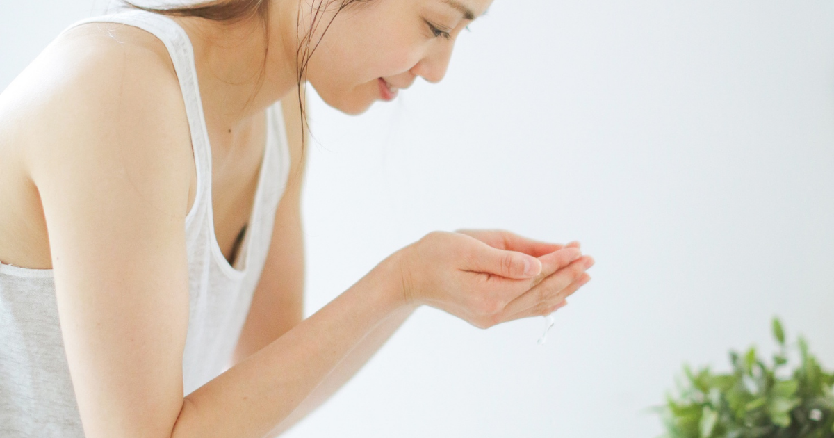 スキンケアアイテムを手に取る女性