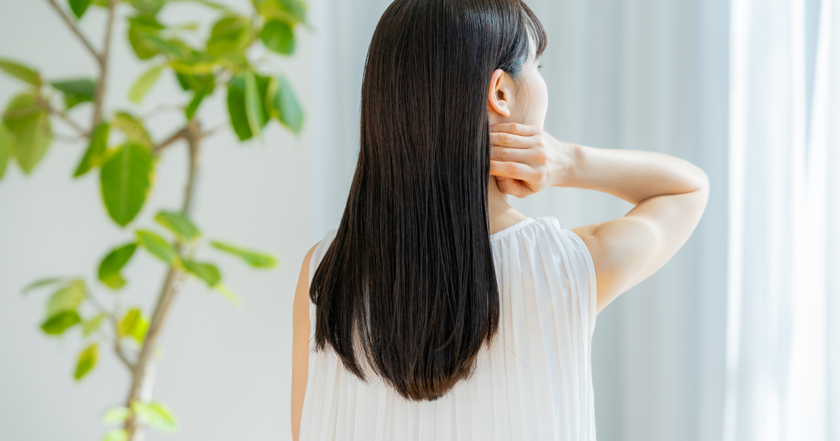 後ろ姿・首元に手・ロングヘア女性
