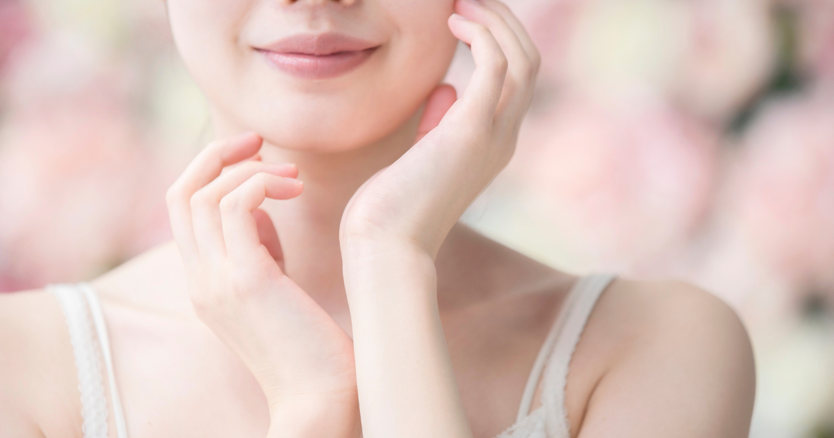 頬に指を添えてナチュラルメイクの仕上がりを確かめる女性