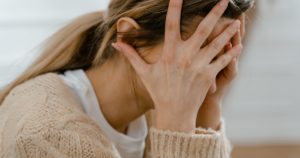 更年期 落ち込み 手で顔を覆い悩む女性