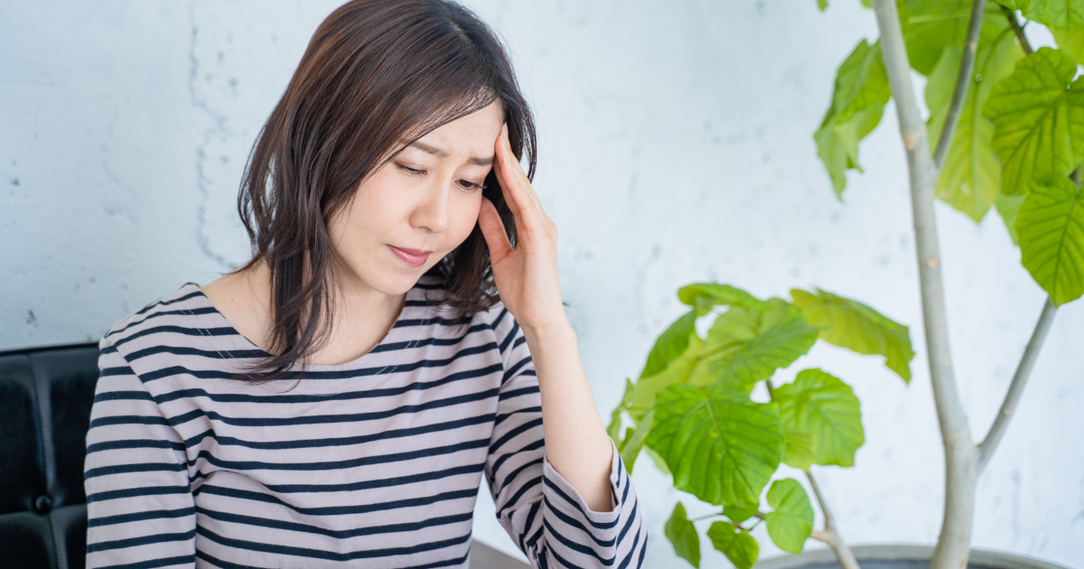 更年期 不安感 頭を押さえる女性 メンタルケア