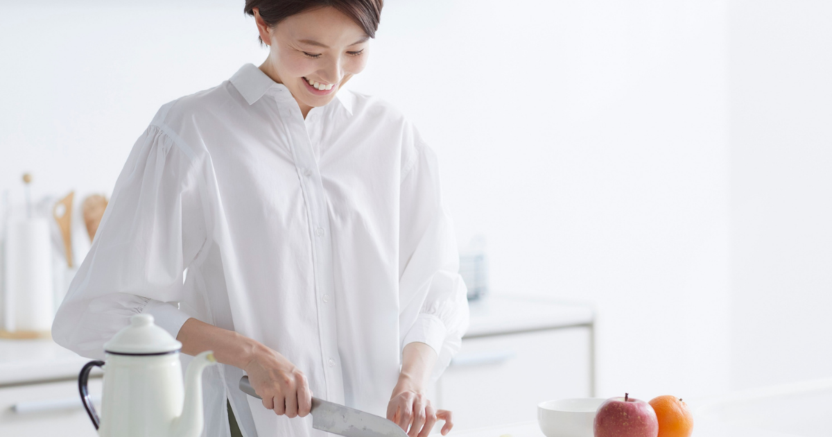 キッチンで野菜を手に取る色白の女性