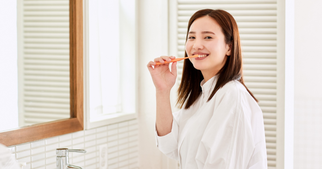 鏡前で歯磨きする女性・白シャツ（人物あり・色白）