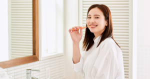 鏡前で歯磨きする女性・白シャツ（人物あり・色白）