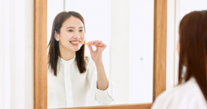 [dental] 鏡の前で歯のケアをする女性（人物あり・色白）