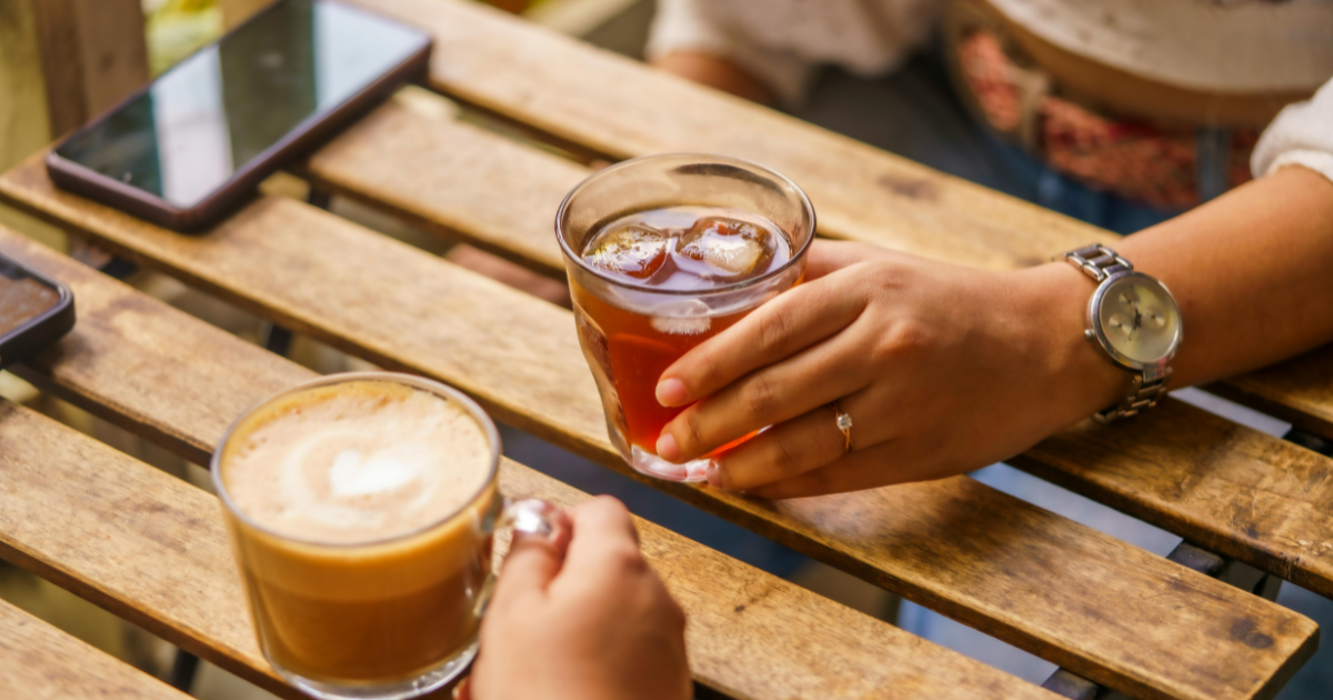 カフェのテーブルに置かれた飲み物と女性の手