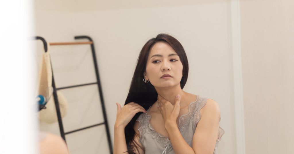 鏡前で首元気にする・ 更年期女性