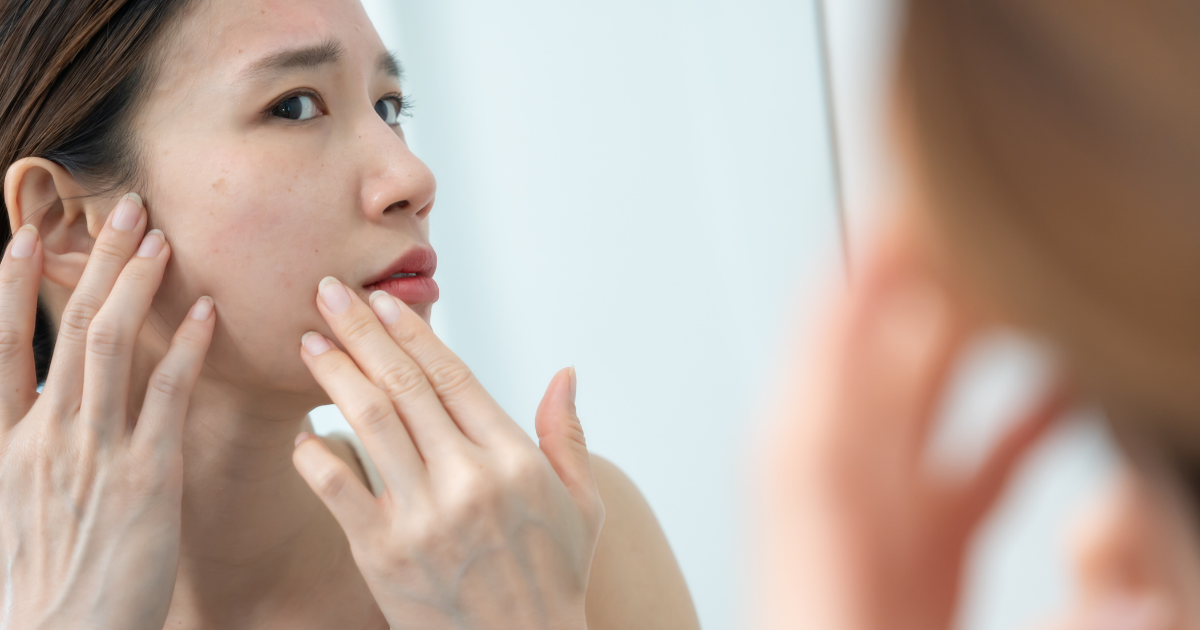 更年期 ほうれい線 鏡で頬を確認するアラフィフ女性