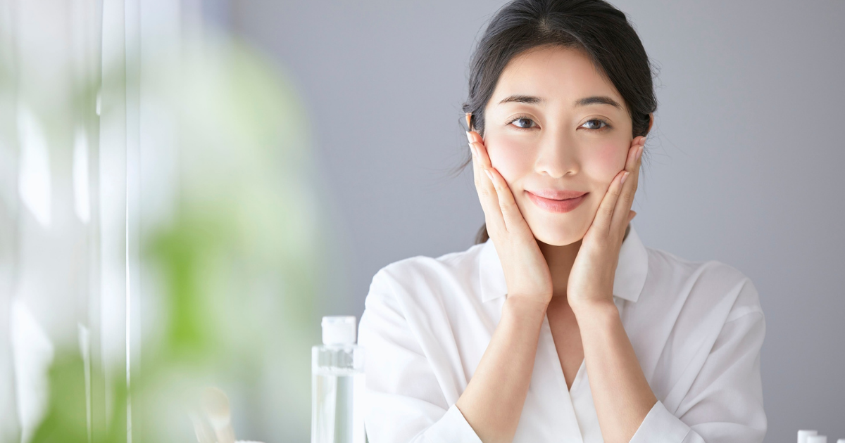 両手で頬を包む笑顔・スキンケア