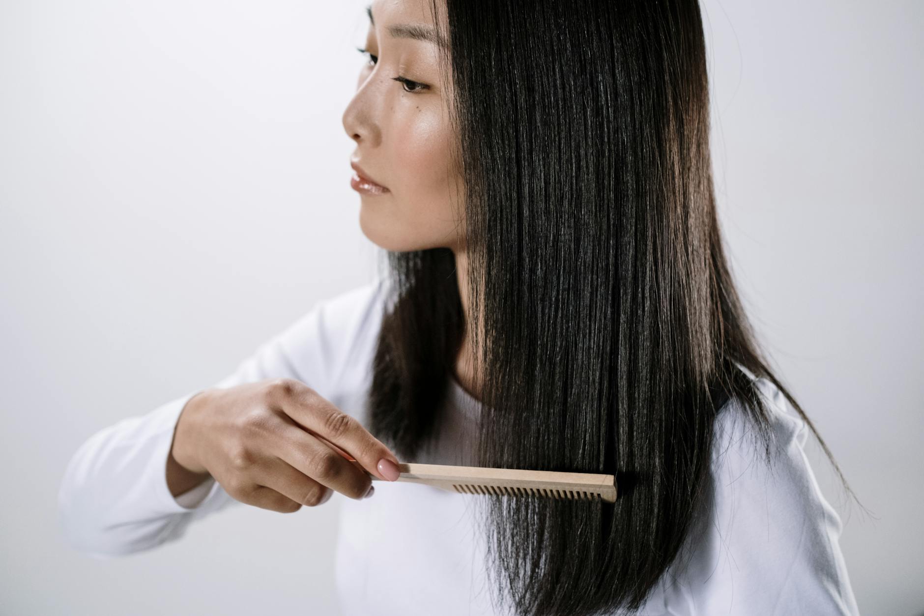 長い黒髪を櫛でとかす女性