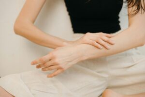 更年期世代の女性が肌ケアで腕をなでるシーン 脱毛後のスムーズな肌