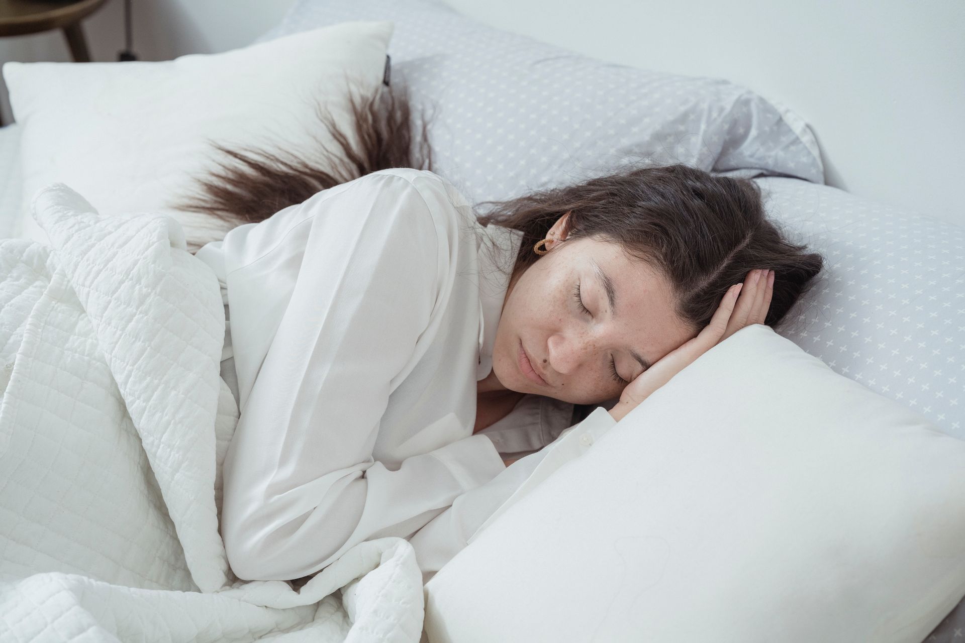 白いパジャマで穏やかに眠る女性